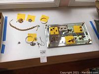 Full view of jewelry pieces and mirrored tray arranged on surface.