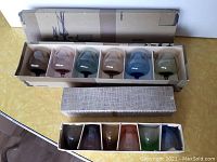 Set of 6 colored glass snifters in original box showing a variety of colors including brown, blue, green, and pinkish tones.