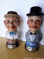 Both ceramic decanter bottles side by side showing full front views with Jim Beam labels and character names.