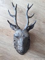 Front view of cast iron deer head showing detailed antlers and facial features.