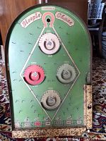 Front view of the wooden Steeplechase game board showing scoring rings, point markings, and spring mechanism handle at the right.