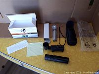 Full view of all items included: telescope, tripod in box, eyepiece, carrying case, cleaning cloth, wrist strap, instruction sheet, and lens cover.