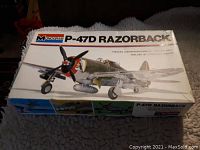 Top of model kit box with illustration of the P-47D Razorback aircraft and Monogram branding
