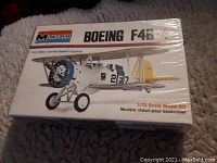 Top view of sealed box with artwork of Boeing F4B-4 biplane in U.S. Navy colors and markings.