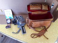 Full lot showing the Yashica 8mm camera, exposure meter, manuals, and leather carrying case open to display interior.