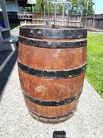 Front view of antique oak water barrel showing metal bands and wood surface