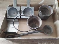 Photo of entire set in cardboard box, showing lead weight mold halves, crucibles, and ladle