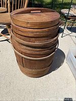 Full view of the antique wooden barrel with the lid on top, highlighting its size and construction.