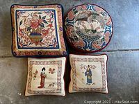 Top view showing four embroidered decorative pillows with Asian motifs and vibrant colors.