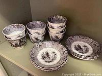Seven soup cups and six saucers with brown Mulberry ironstone transferware pattern arranged on shelf.