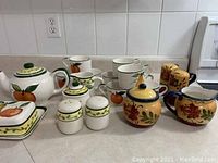 Photo showing full coffee and tea set including cups, teapots, butter dish, shakers, and other ceramic accessories.