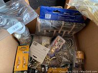 Box containing assorted metal hooks and clips, package of 24 hooks, loose screws and mounting components