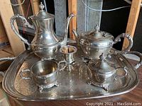 Full six-piece silver tea service displayed on large engraved tray