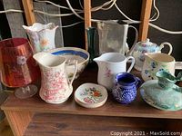 Overall group of various vases, jugs, teapot, and plates displayed on wooden shelf