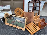 Photo of various handcrafted wooden items including calendar holder with hooks, magazine basket with heart cutouts, cut wooden containers, coat rack, and two small stools painted with birds and roses.