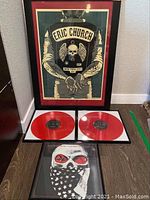 Full view of framed poster, two red vinyl records, and framed skull picture.