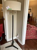 Full view of floor lamp showing shade, stand and tripod base