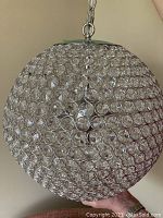 Close-up view focusing on the faux crystal elements and chrome rings that form the chandelier's spherical body.