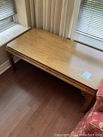 Full view of the rectangular wood coffee table showing top surface and legs.