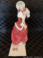 Front view of the Royal Doulton 'Christmas Morn' figurine showing the woman in red with white fur trim and bonnet.