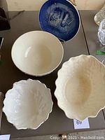 Top down view of two large vintage Spode serving bowls (one oval with crazing, one round), blue Royal Copenhagen plate in background, white Coalport cabbage leaf bowl