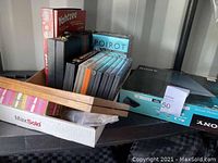 Photo showing DVDs, Yahtzee game box, playing cards, and a wooden game case.