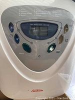 Close-up of the breadmaker digital control panel showing baking options and buttons.