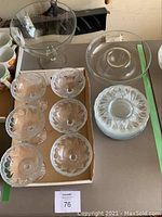 Image showing six clear glass stemmed dessert bowls with heart patterns and a large footed glass bowl along with plates and chip and dip bowl on table