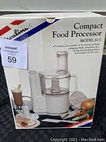 Photo of the original closed product box showing Moulinex Compact Food Processor Model 813, with text describing accessories and motor power. Box features images of food items and the appliance.