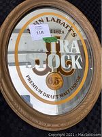 Front of oval bar mirror showing John Labatt's Extra Stock logo with oak-colored resin frame and glass mirror surface.