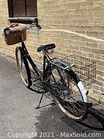 Left-side full view of bicycle showing frame, front and rear baskets, rack and fenders