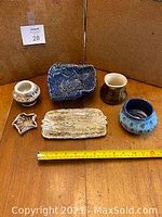 Photo showing all six ceramic pieces together on wooden table with measuring tape.