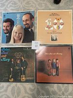 Photo of four Peter Paul and Mary albums laid on the floor, covers visible showing title and photos of band members.
