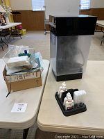 Photo showing the clear TruVu aquarium tank with black top and base, and a small organizer with assorted liquid bottle accessories