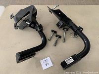 Two black metal TowMaster Falcon 2 tow mounting brackets positioned side-by-side with four bolts, two pins with clips, and an auction card labeled 53.