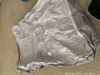 Full view of the light gray Aerobed air mattress uninflated, showing the fabric surface and edges.