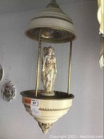 Front view of hanging oil rain lamp showing canopy, chain cascade, and central figurine