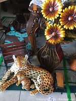 Leopard and cub ceramic figurine with Italian mark, sunflower fan in background, and metal wire decorative vase