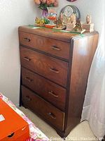 Front view of antique wood dresser showing all four drawers and handles