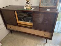 Front view showing speaker grille, radio dial, control knobs and push buttons