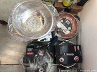 Top view showing multiple cookware items including stock pot, frying pans, and plastic-wrapped containers.