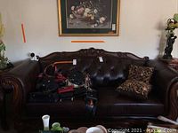 Front view showing tufted back and carved wood frame