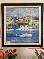 Framed watercolor painting hanging on a wall showing a scenic marina with a white whale and white doves above the water