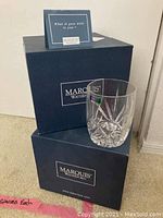 Two original dark blue Marquis Waterford boxes stacked with one crystal glass displayed on top showing the star cut pattern and brand sticker.