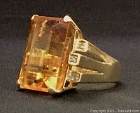 Oblique side view showing the step-cut citrine and split shank with three diamonds on one side.