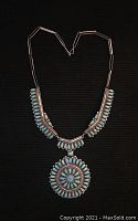 Full view of necklace laid out showing entire medallion pendant and collar chain