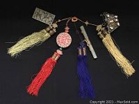 Full view of the four-tassel jade hanging ornament with amber suspension ring and multicolored tassels