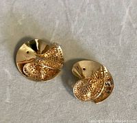 Two 14K gold fan-flair earrings placed on fabric background showing the flared disc shape with pierced openwork details and one hole for missing wires.