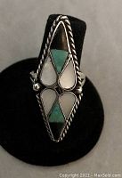 Front view of the Native American diamond-shaped ring with turquoise and shell inlays surrounded by a twisted silver rope motif.