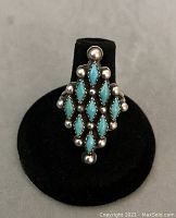Front view of diamond-shaped Navajo turquoise and silver ring showing nine turquoise stones and silver ball details.